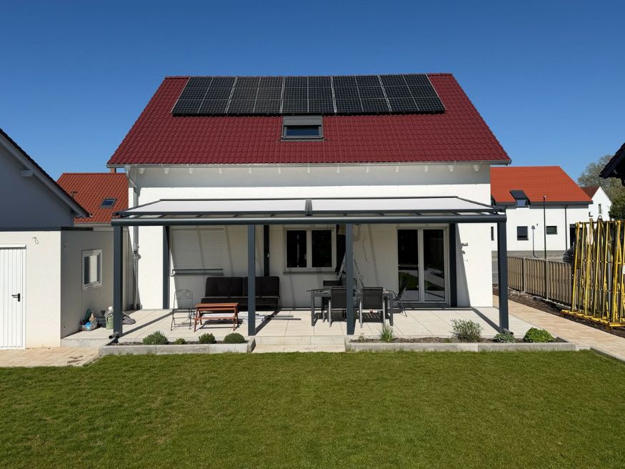 Hochwertige Terrassenüberdachung mit Aluminiumkonstruktion und Glasdach an einem modernen Einfamilienhaus in Essen.