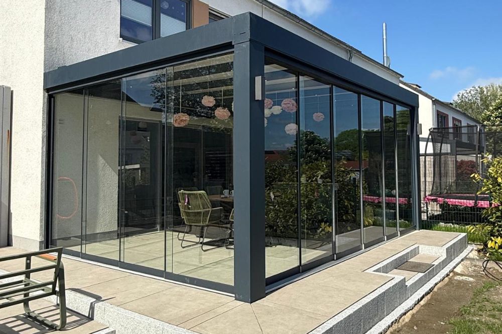 Hochwertiger Wintergarten in Dortmund mit Aluminiumkonstruktion, bodentiefen Glasschiebeelementen und modernem Design als Erweiterung des Wohnraums.